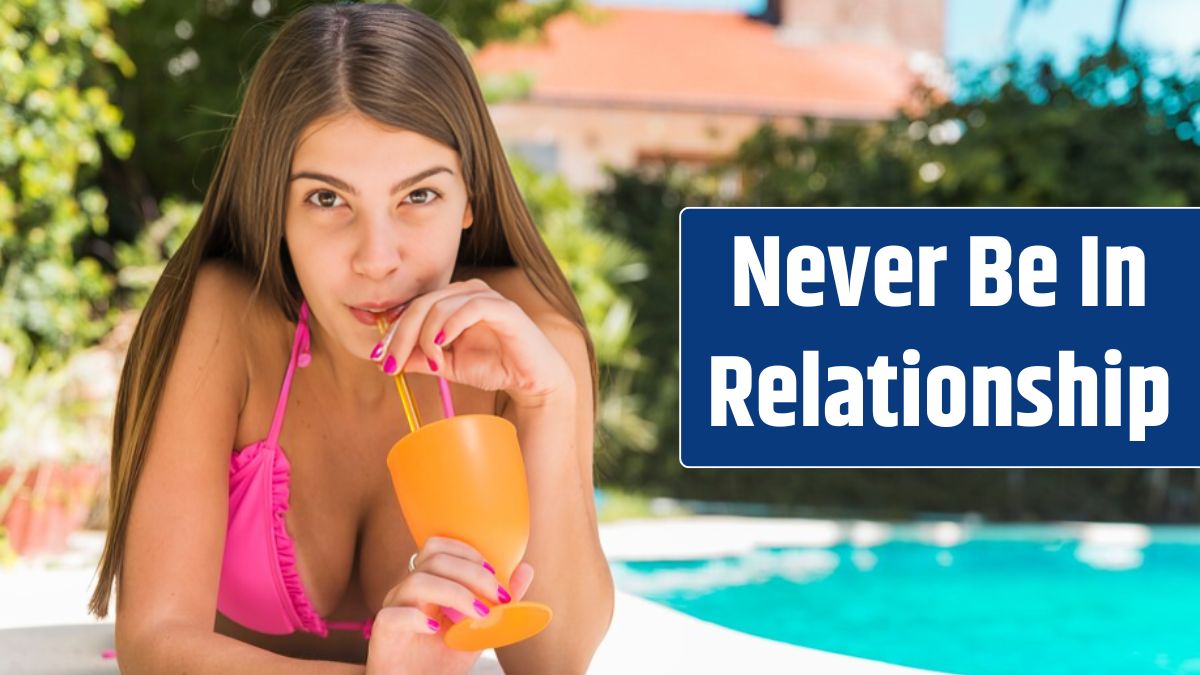 Pretty young woman drinking cocktail near pool.